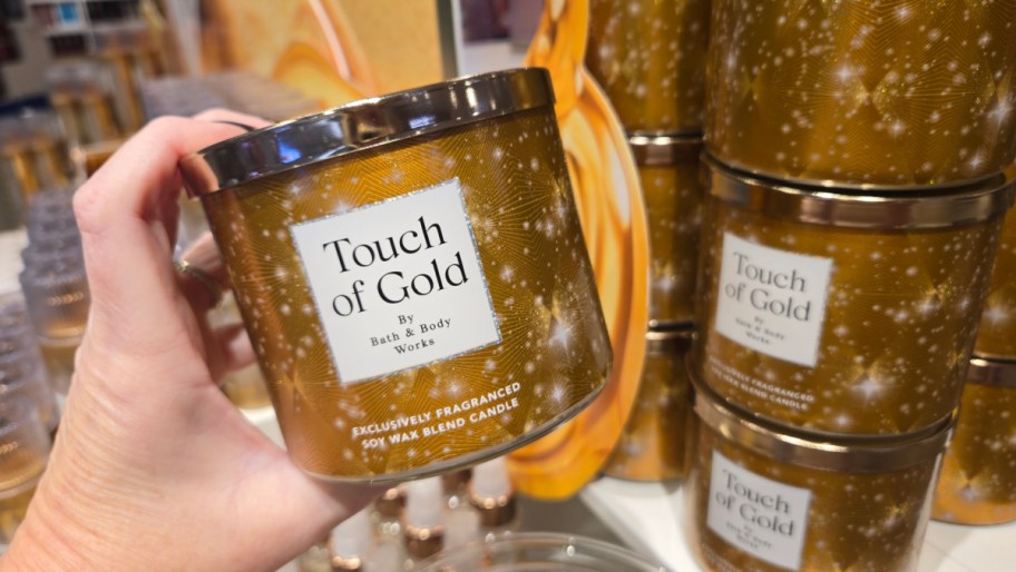 hand holding up a bath and body works 3 wick candle