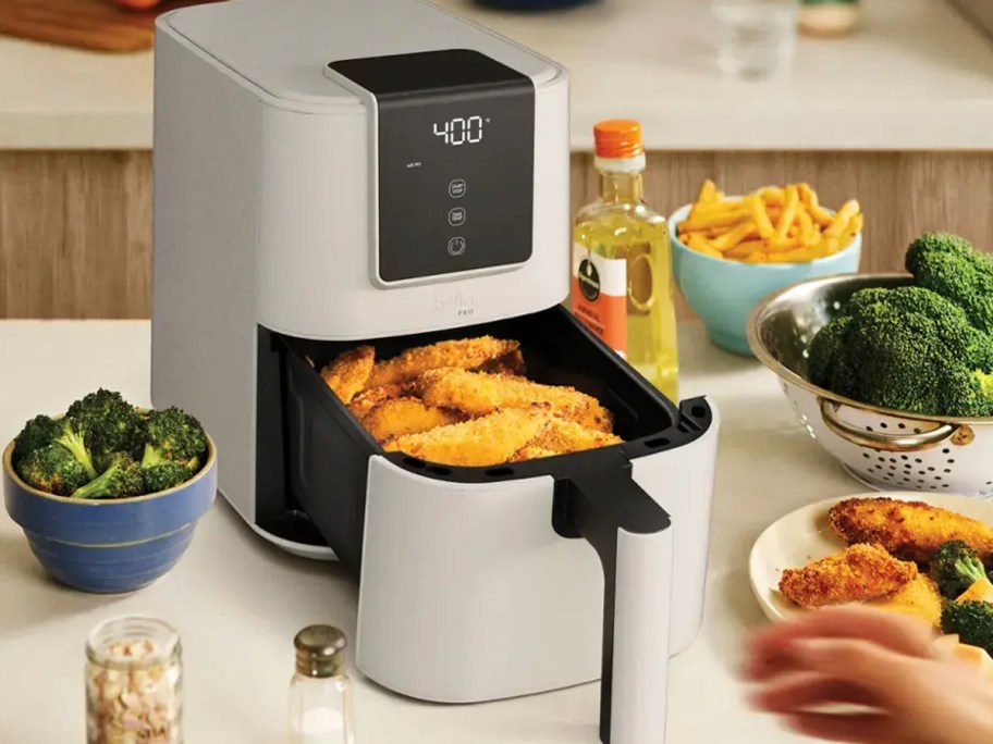 gray bella air fryer with chicken in basket on table