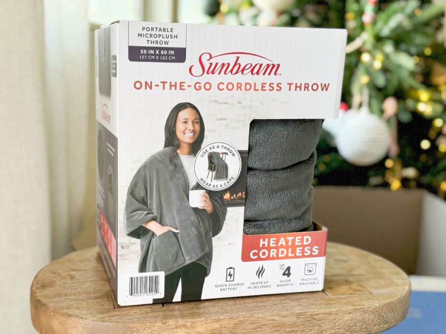Sunbeam On-the-Go Cordless Wearable Heated Throw Blanket box on stool
