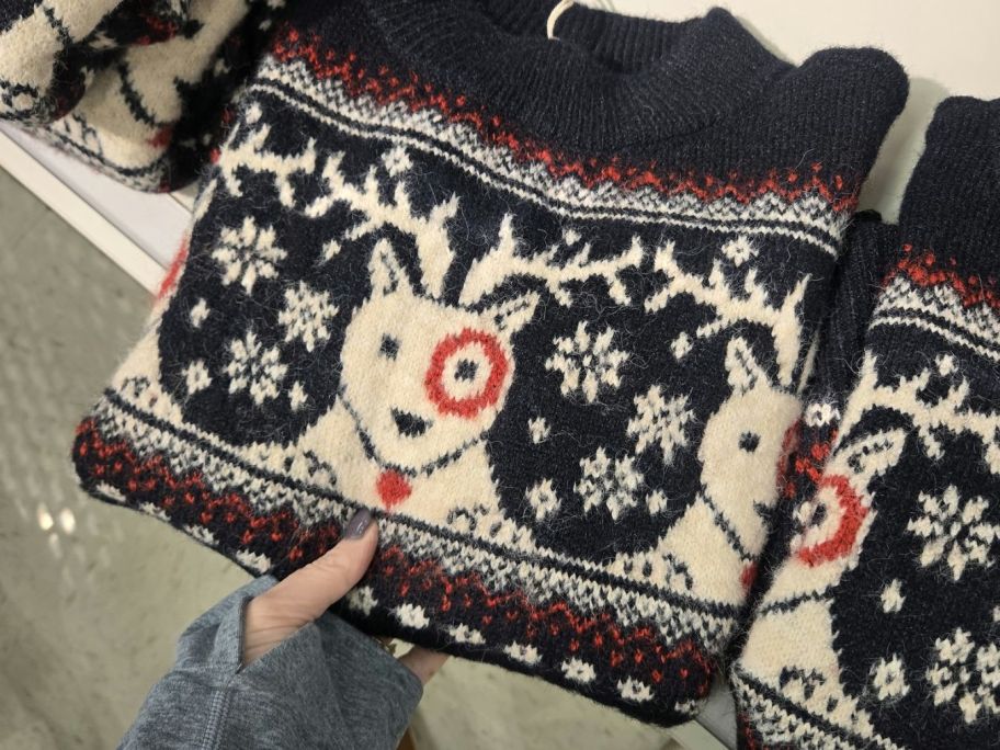 hand holding target bullseye holiday sweater in store