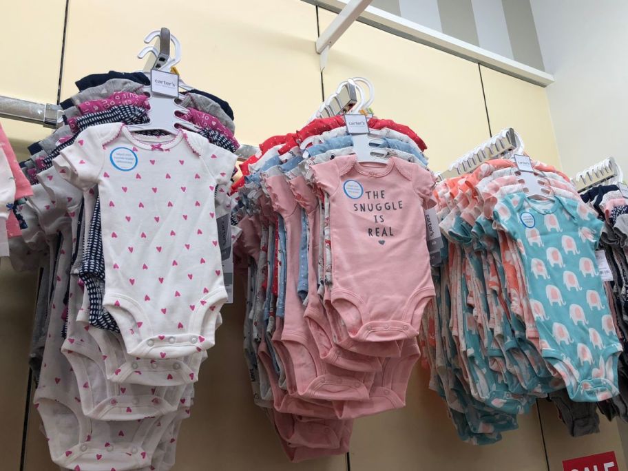 baby and toddler onesies hanging on a rack in a store