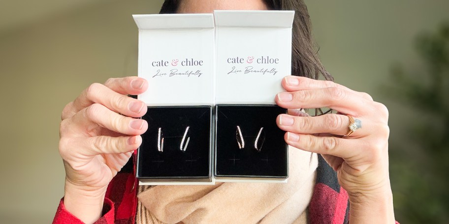 woman holding two cate and chloe earring boxes 