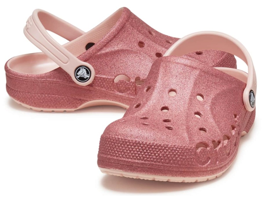 a pair of pink glitter kids Crocs clog shoes