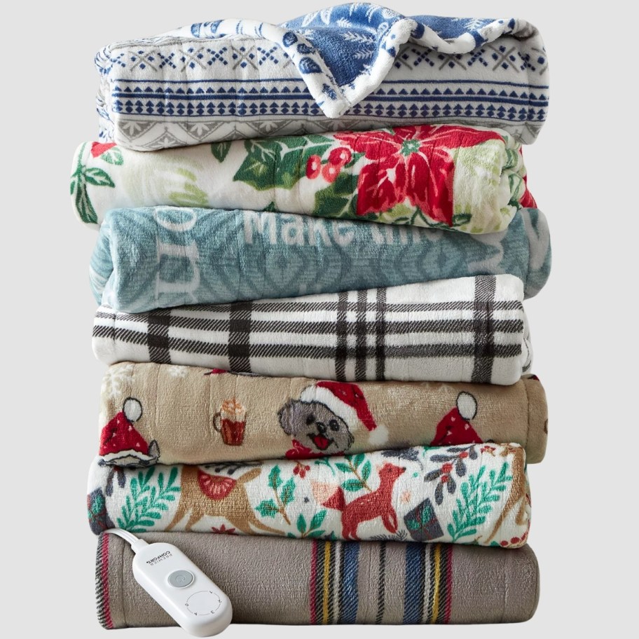 a stack of christmas themed heated throws