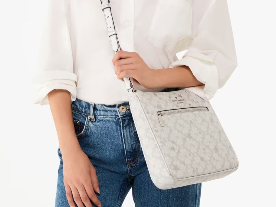 woman wearing jeans and a white button down shirt with a white and light grey print crossbody bag