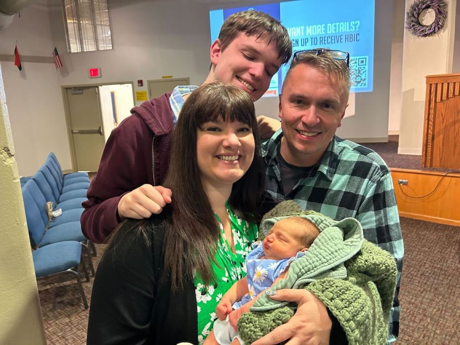 family holding baby in church