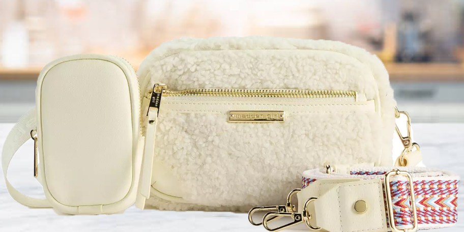 white purse with strap and small bag on counter