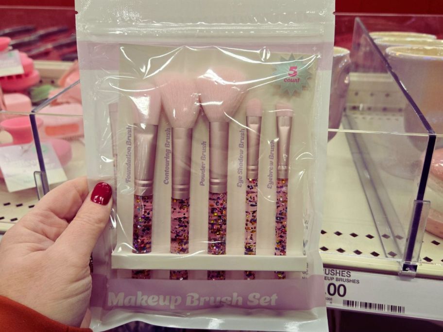 hand holding pink makeup brush set