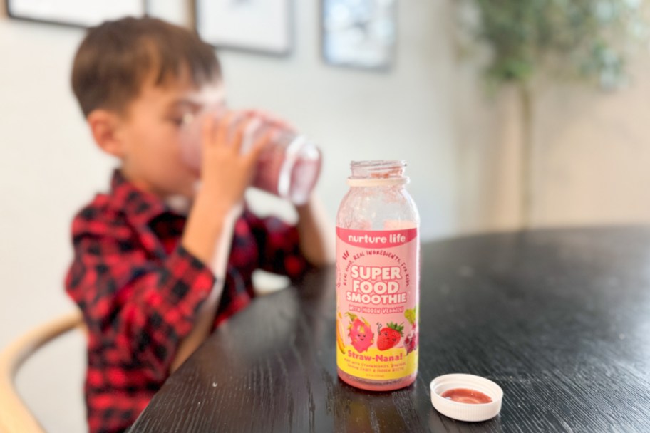 boy drinking smoothie on table