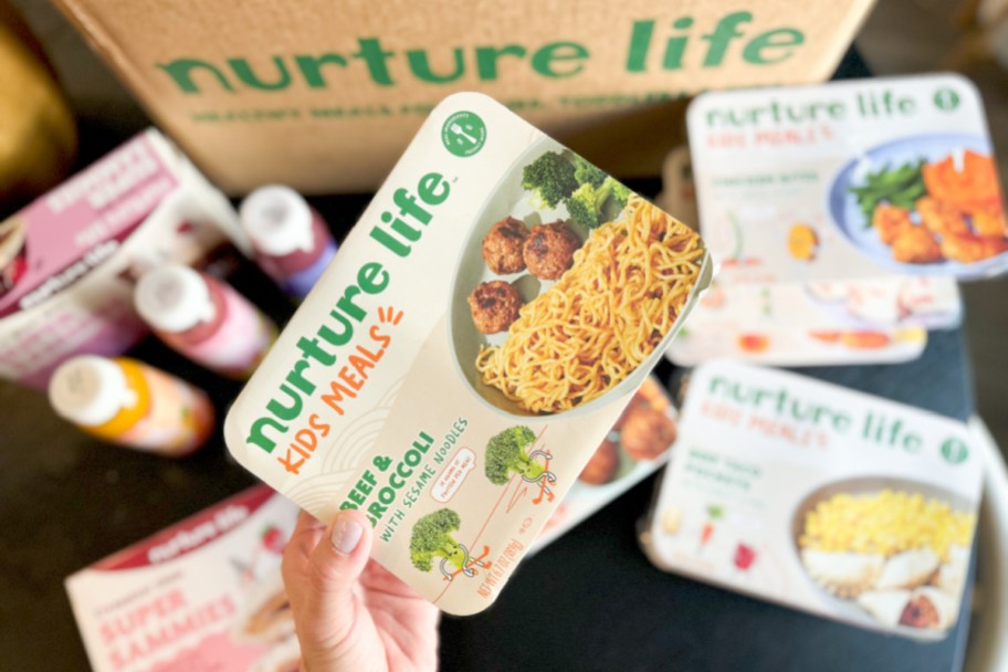 hand grabbing kids frozenmeal next to box of goodies