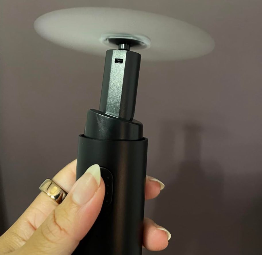 hand holding mini black portable fan