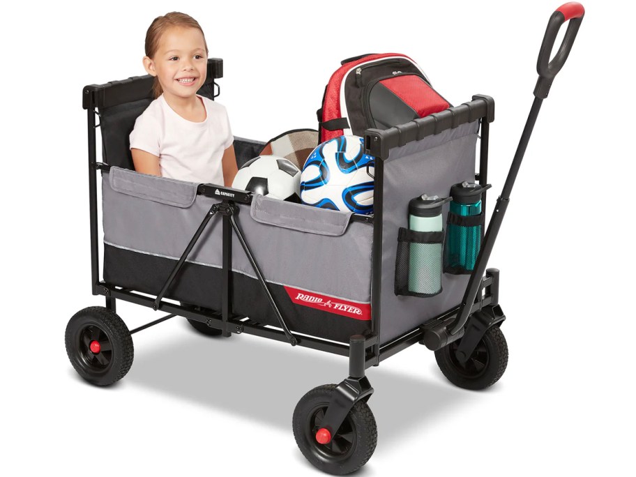 gray radio flyer wagon with child sitting in it with soccer equipment