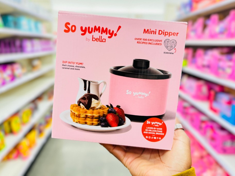 hand holding mini pink slow cooker in box