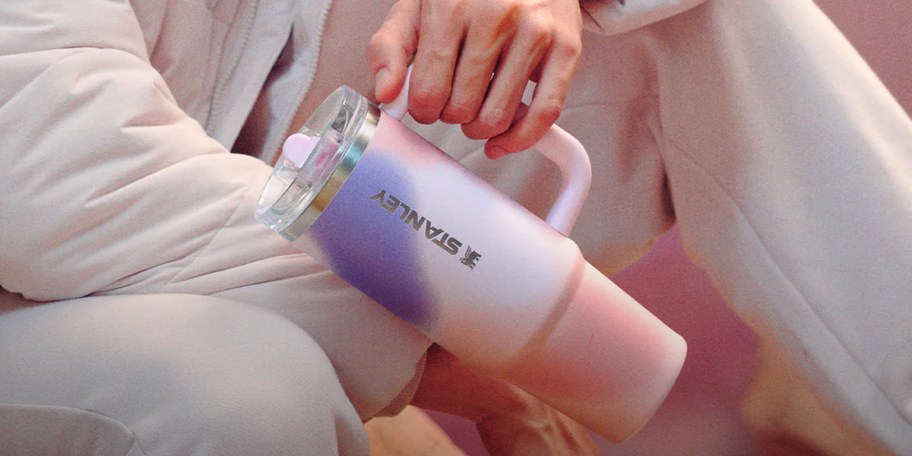 hand holding pink and purple tumbler