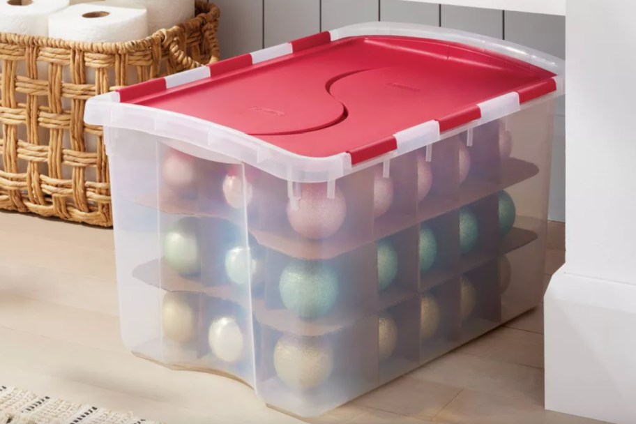 clear bin with red lid and ornaments inside