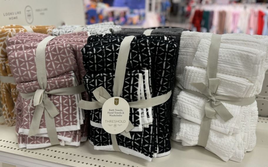 3 bath towel sets on a store shelf