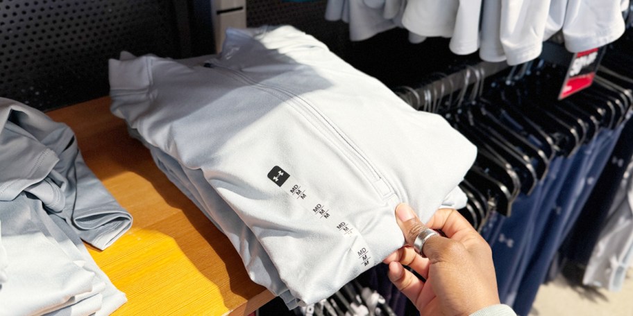 hand reaching for gray zip jacket