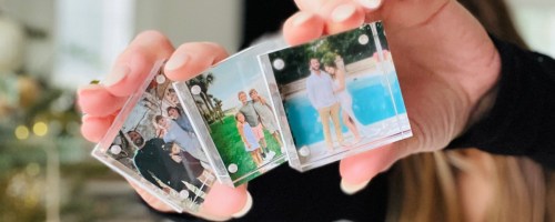 woman holding 3 acrylic photo blocks in front of face