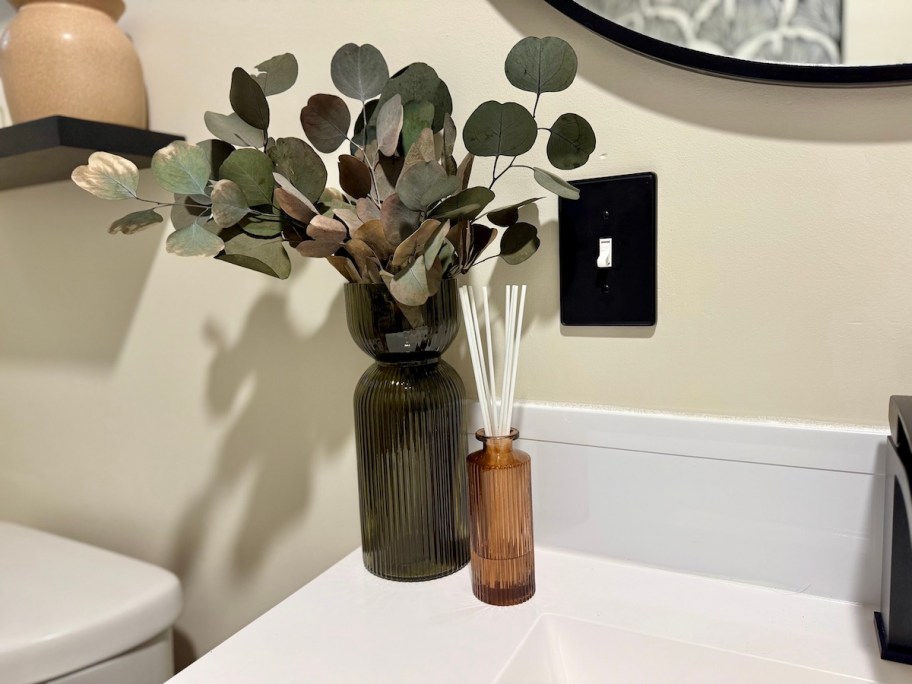 amber ribbed vases on white bathroom counter