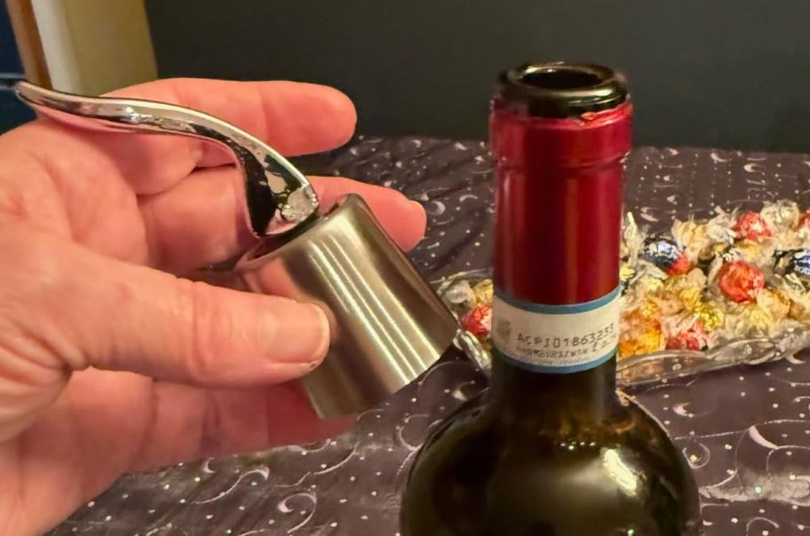 Hand holding a stainless steel wine bottle stopper