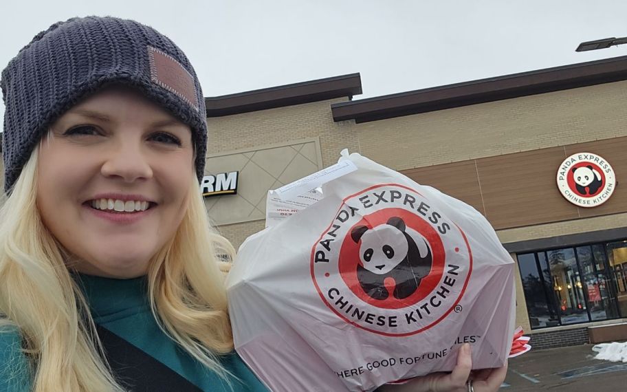 a woman with a panda express to go order outside a panda express