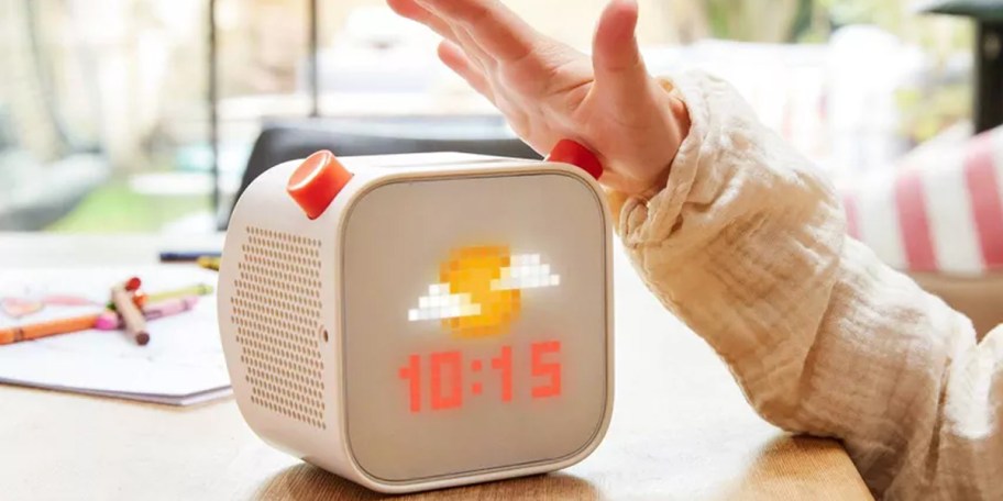 hand reaching for yoto audio player on table