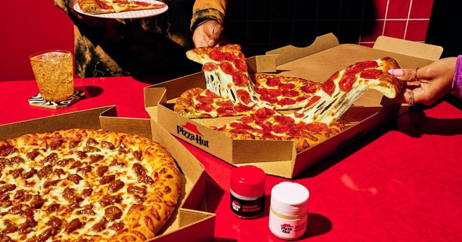 people pulling slices of Pepperoni Pizza from a Pizza Hut box