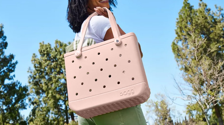 woman holding a light pink baby bogg bag