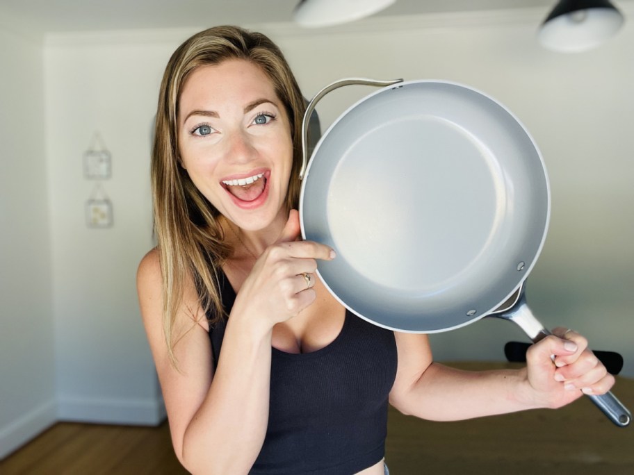 Woman holding a frying pan from Caraway Cookware Set