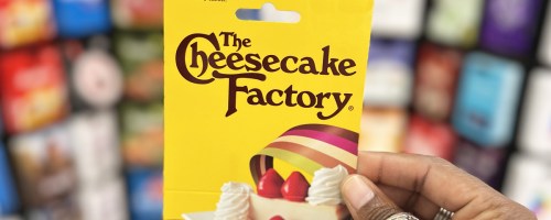 hand holding up a yellow Cheesecake Factory gift card