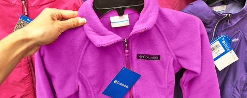 hand holding up a purple columbia fleece zip-up in store