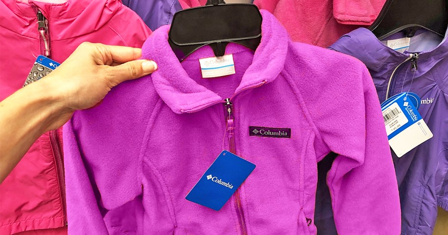 hand holding up a purple columbia fleece zip-up in store