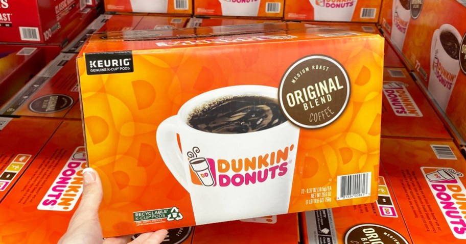 hand holding a large orange box of dunkin k-cups in store