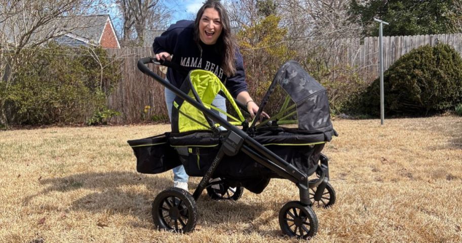 A woman standing behind a stroller even in the yard