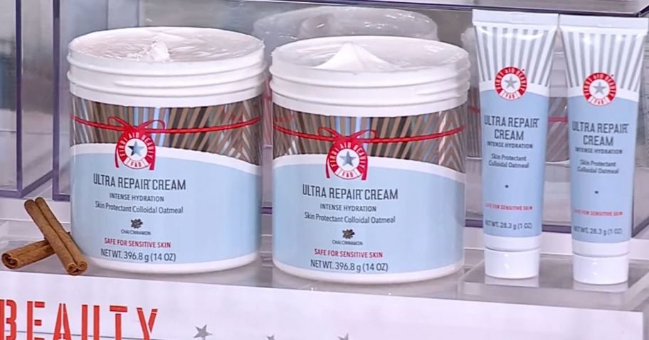 Two First Aid Beauty Super Size Ultra Repair Creams and two mini travel size tubes on a display