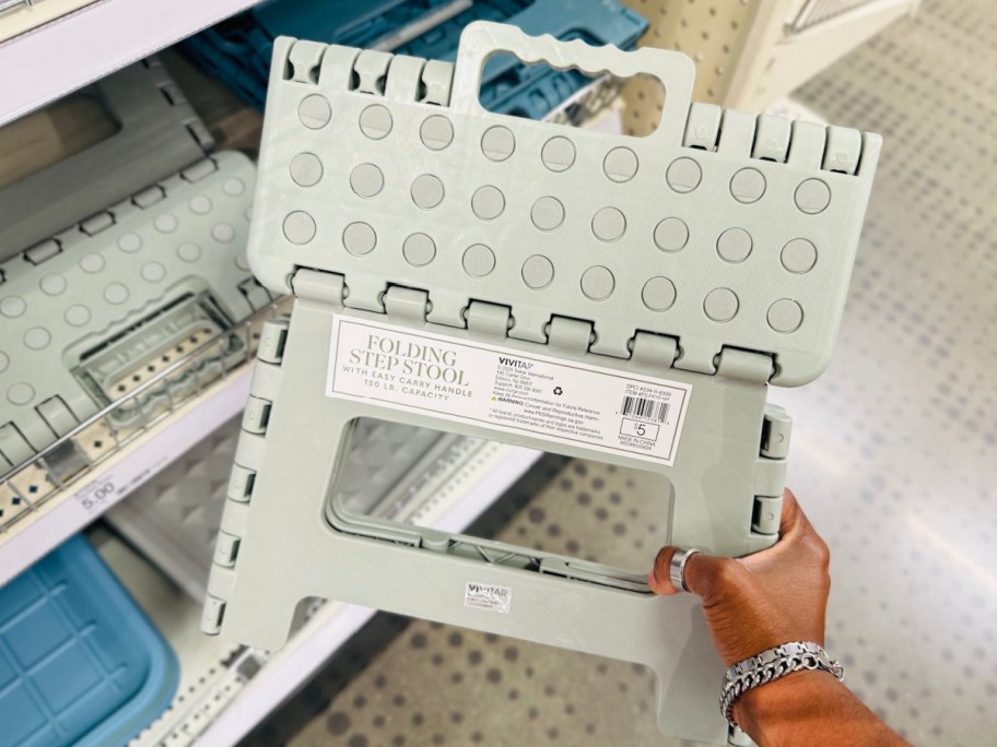 Folding step stool displayed in womans hand