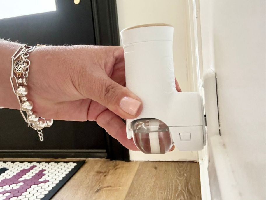 A person plugging in a Glade Essential Oil Infused Wall Plug