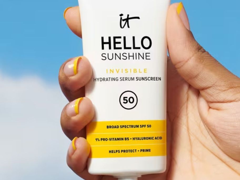 hand holding a tube of It Cosmetics Hello Sunshine Invisible Facial Sunscreen w/ SPF 50 1.7oz