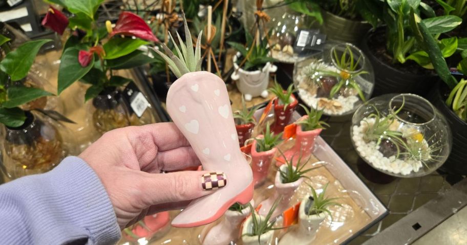 A person holding a pink boot planter