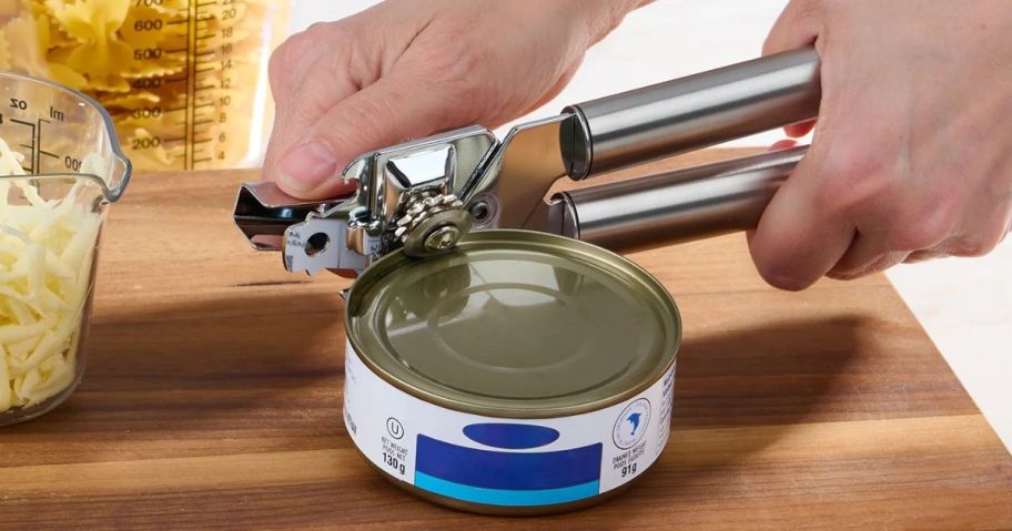 Hand using a Mainstays Can Opener to cut the lid off a tuna can