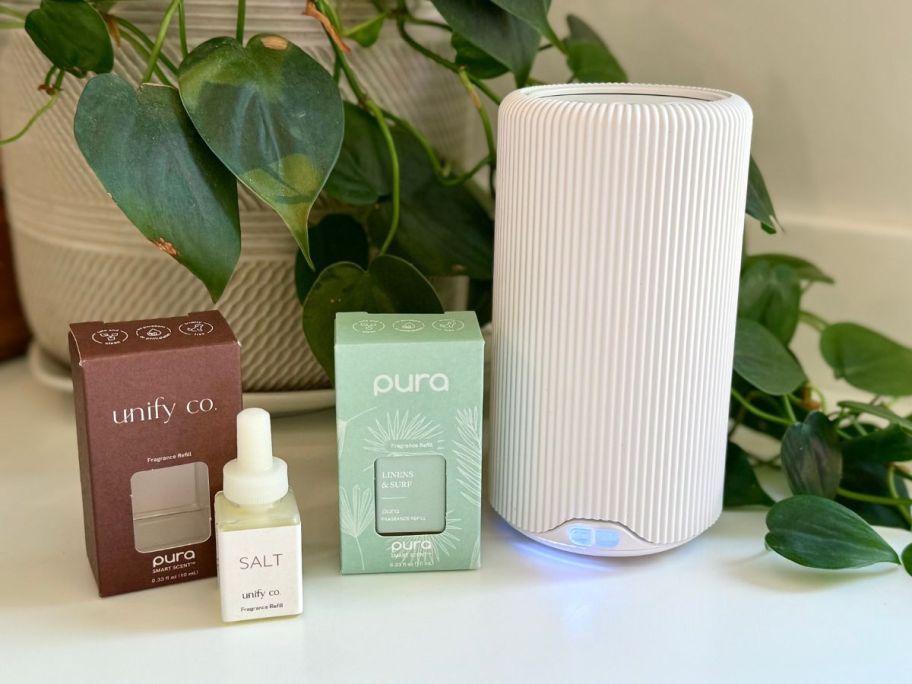 A Pura Smart Diffuser with two refills