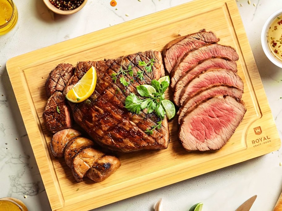 sliced steak on top of a wood cutting board