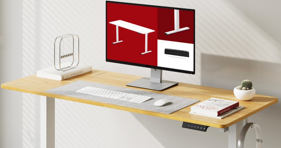 monitor, keyboard, and books on top of a wood desk with white legs