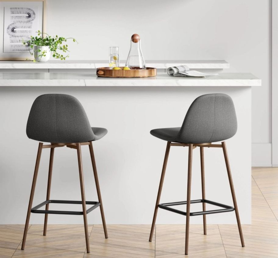 two gray counter height barstools in front of a bar