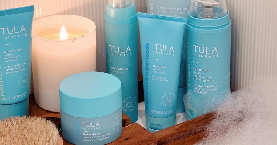 A Bathroom with a candle and several Tula Skincare Products