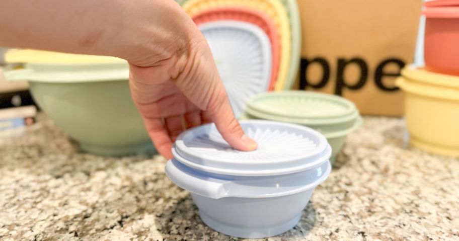 Hand pressing on a Tupperware Heritage Bowl