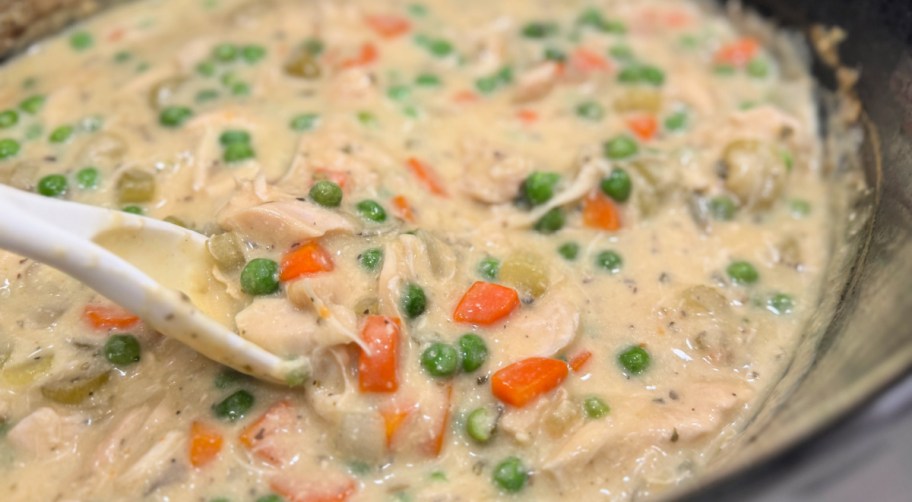 adding frozen peas to dumpling soup