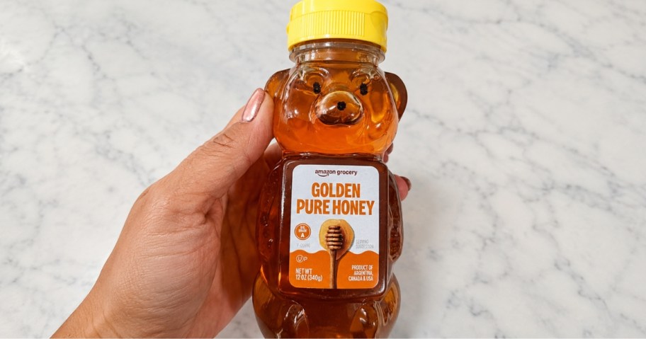 hand holding a bear shaped honey container