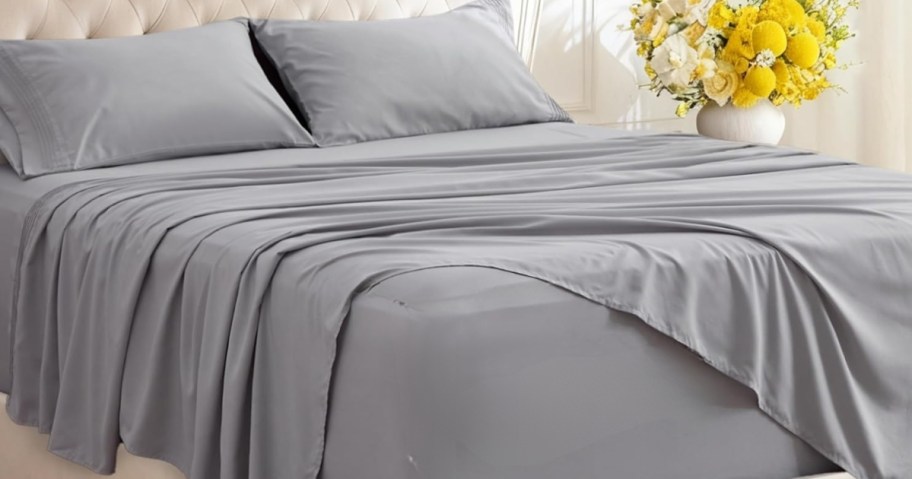 a bed with grey sheets