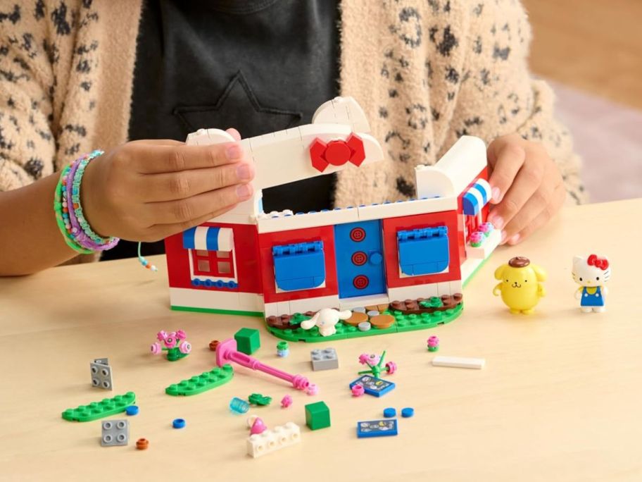 kid playing with BLDR Hello Kitty's Dream Cafe Building Set on table